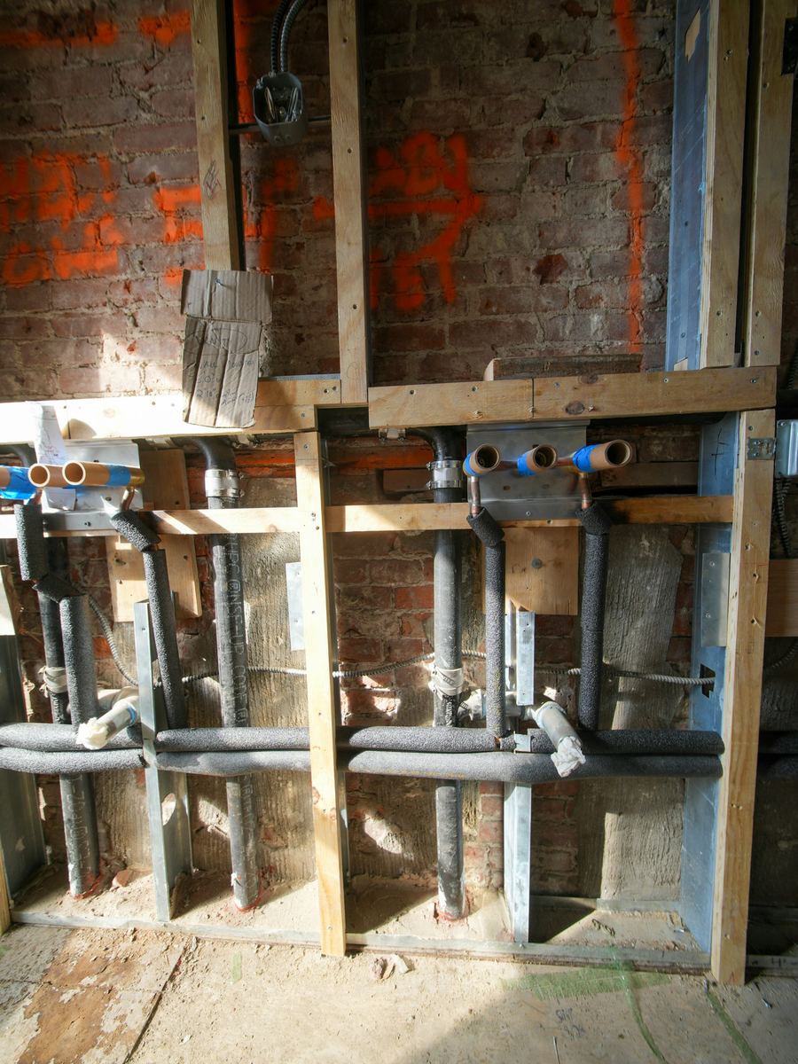 New plumbing roughed in between open wall studs